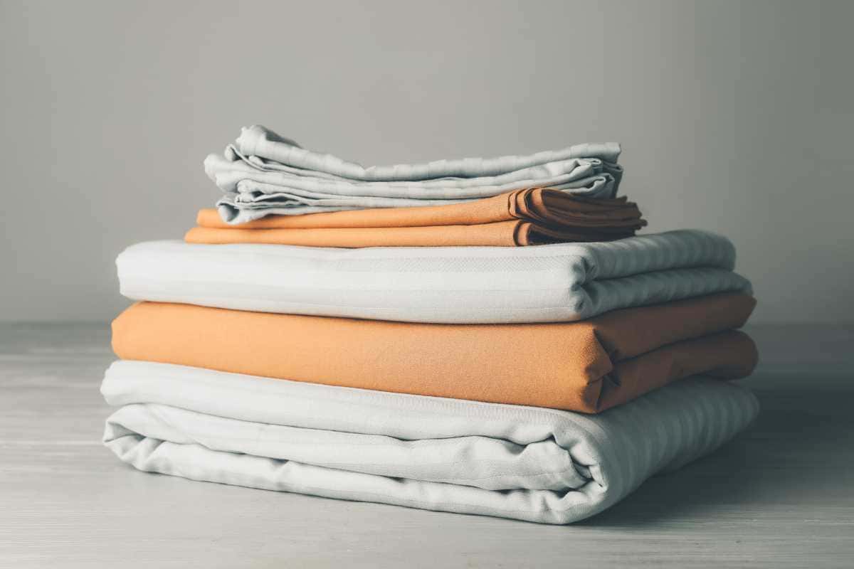 Como dobrar roupas de cama para ocupar metade do espaço